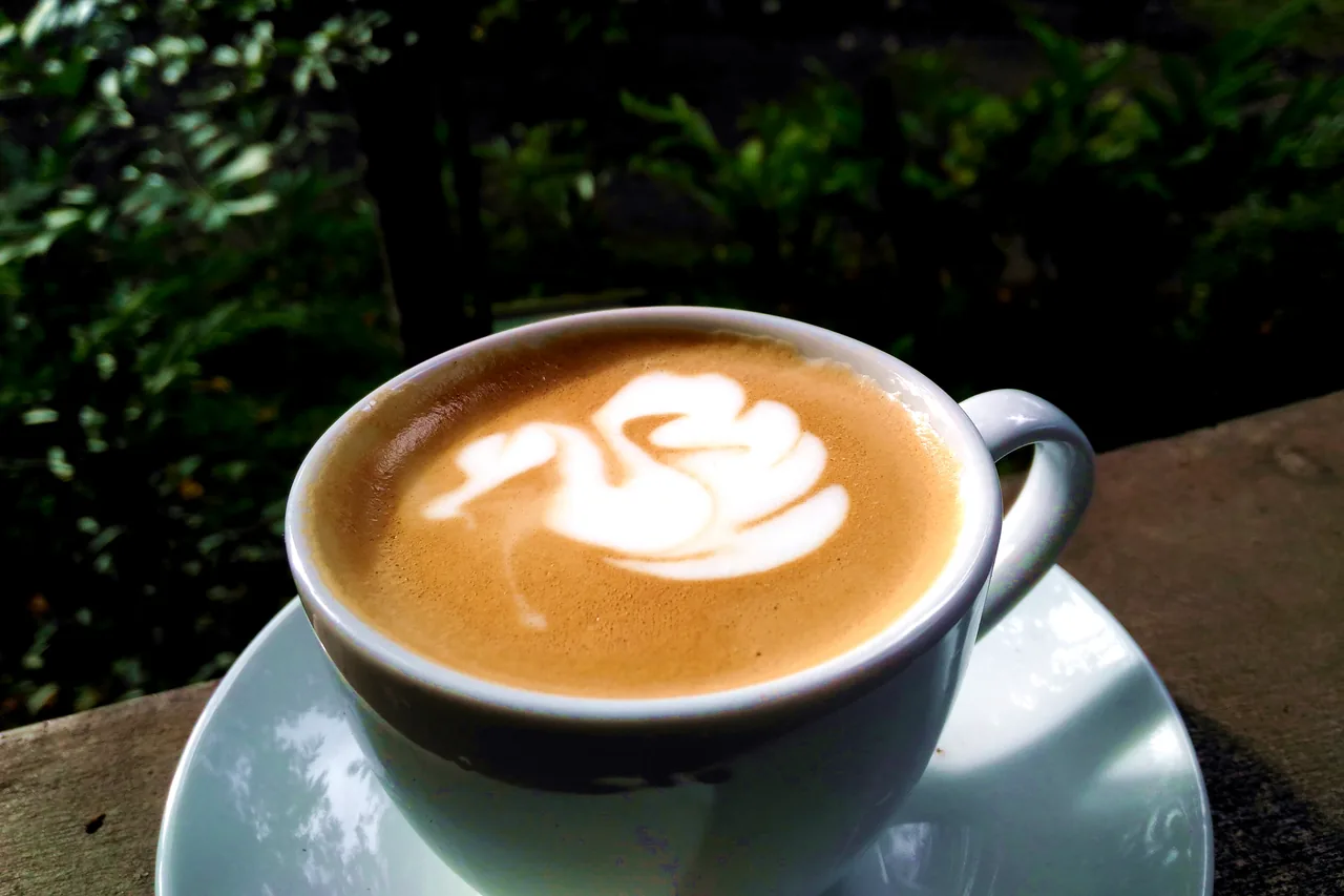 A cup of coffee with latte art on a cafe table