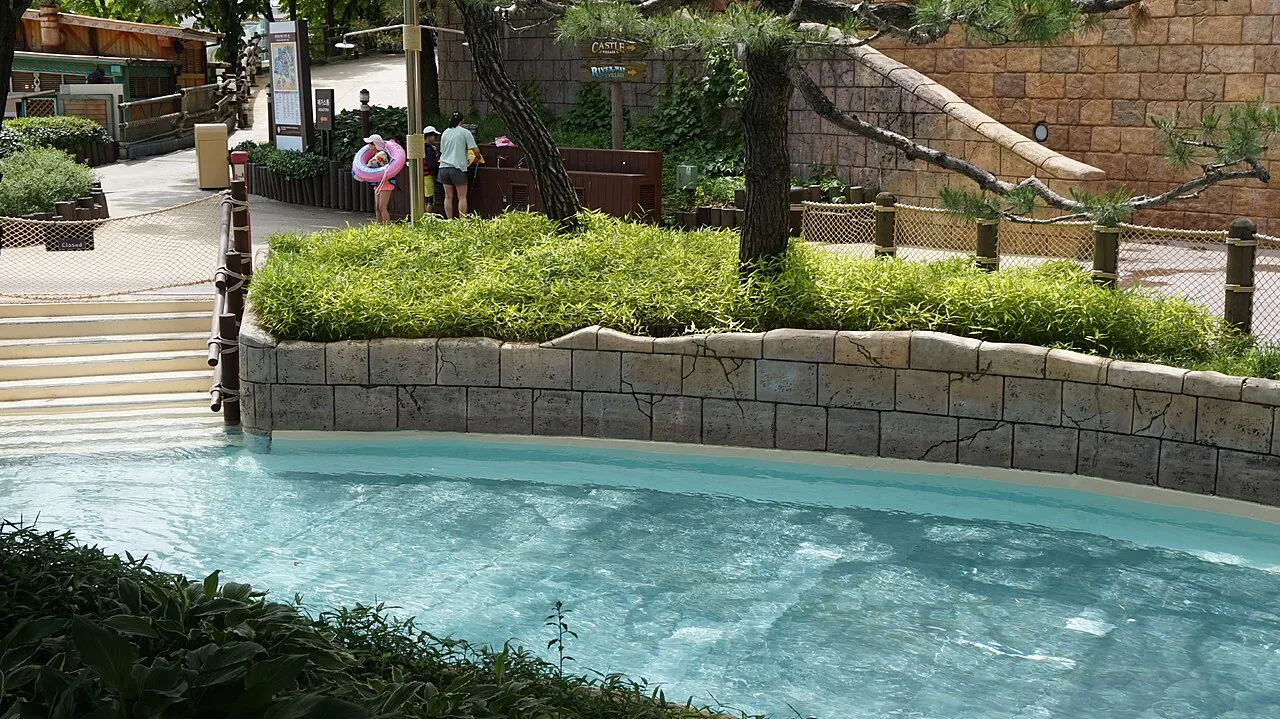 A calm themed pool with stone walls and greenery at Caribbean Bay water park in Yongin