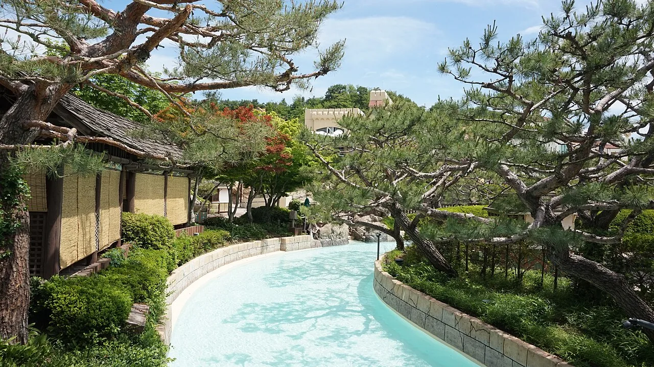 Caribbean Bay's Wild River winding past pine trees toward a hilltop fortress at the Everland water park