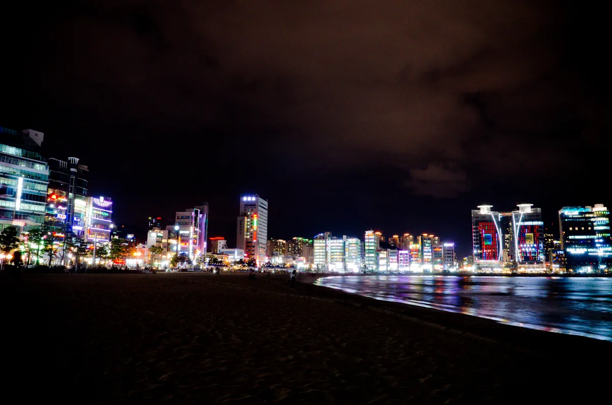 La playa de Gwangalli de noche frente al puente Gwangan iluminado en Busan
