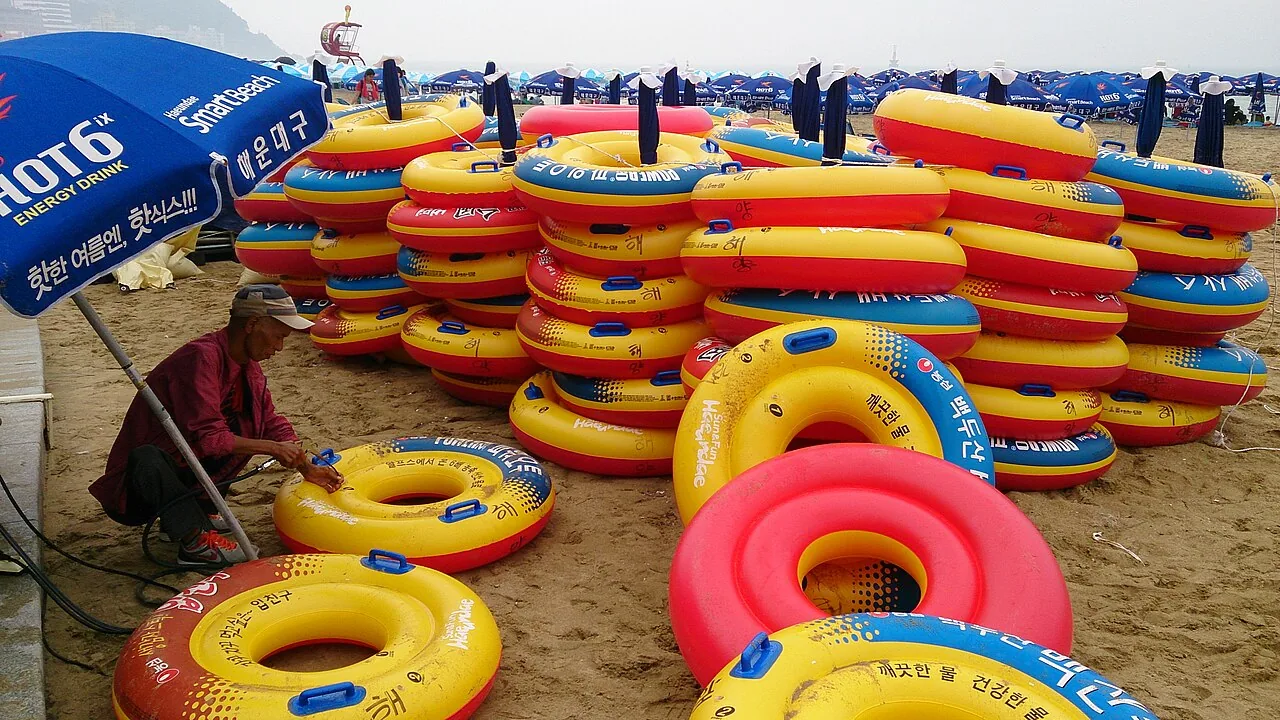 Colourful swimming rings and bathers at Haeundae Beach in Busan on a summer day