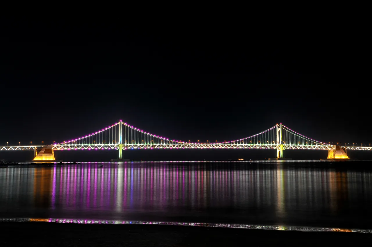 Gwangan Bridge lit up at night over Gwangalli Beach in Busan