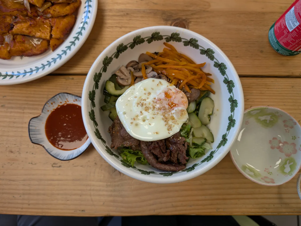 A colourful bowl of bibimbap with vegetables, egg and chilli paste