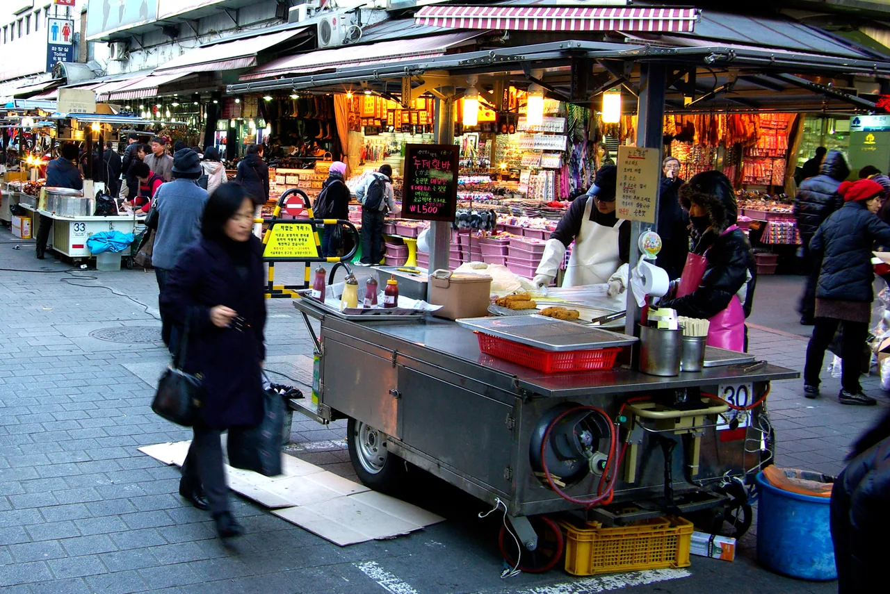 Street food stalls at a Korean market with tteokbokki and snacks