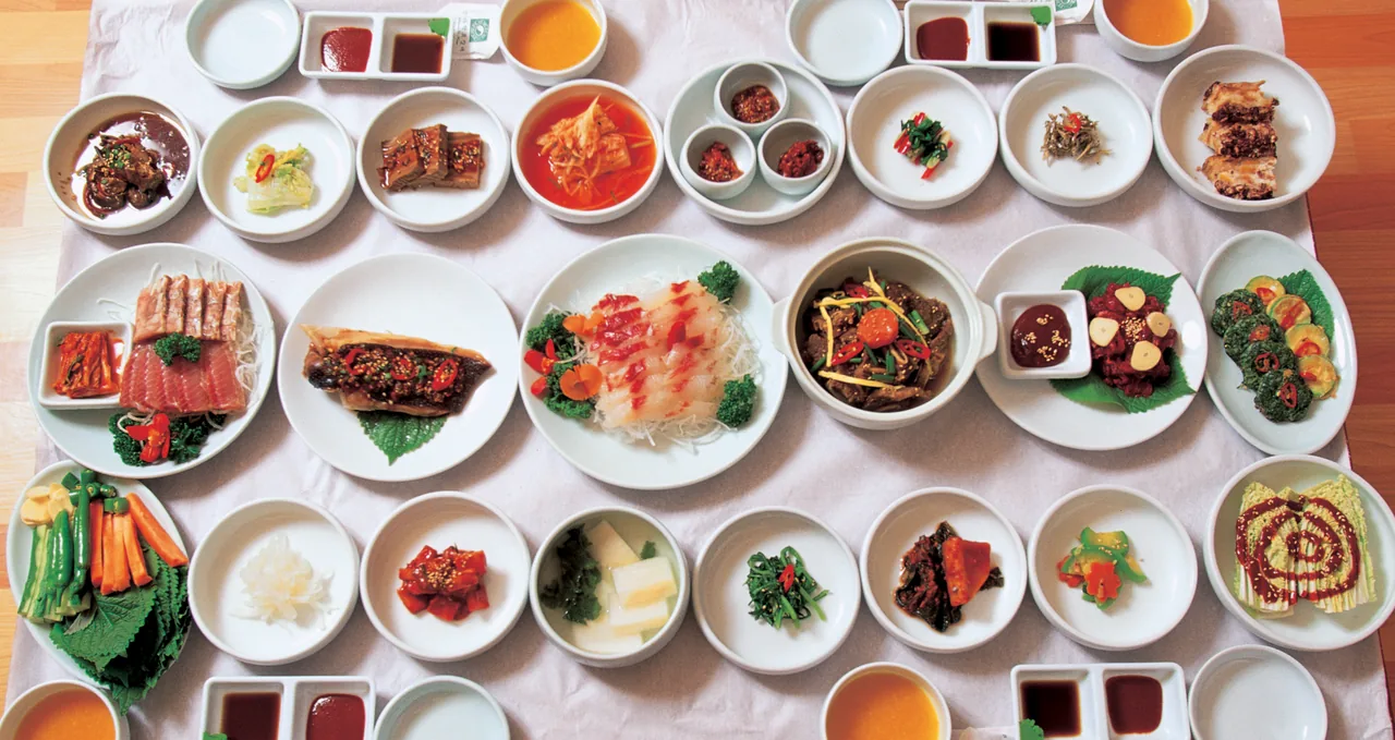A Korean table set with rice, soup, grilled fish and many banchan side dishes