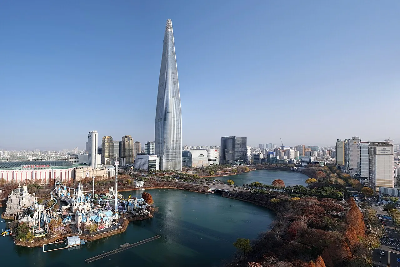 ロッテワールドのマジックアイランドの城と石村湖、後ろにロッテワールドタワーが見える空撮