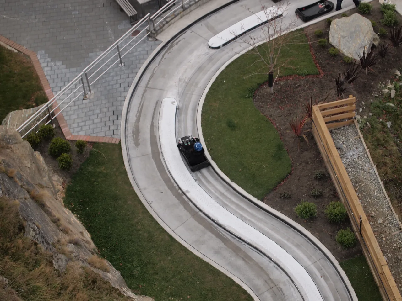 A single Skyline Luge gravity cart on a curving concrete track seen from above
