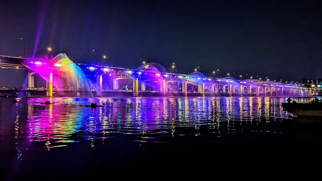 The Banpo Bridge rainbow fountain spraying coloured water over the Han River at dusk