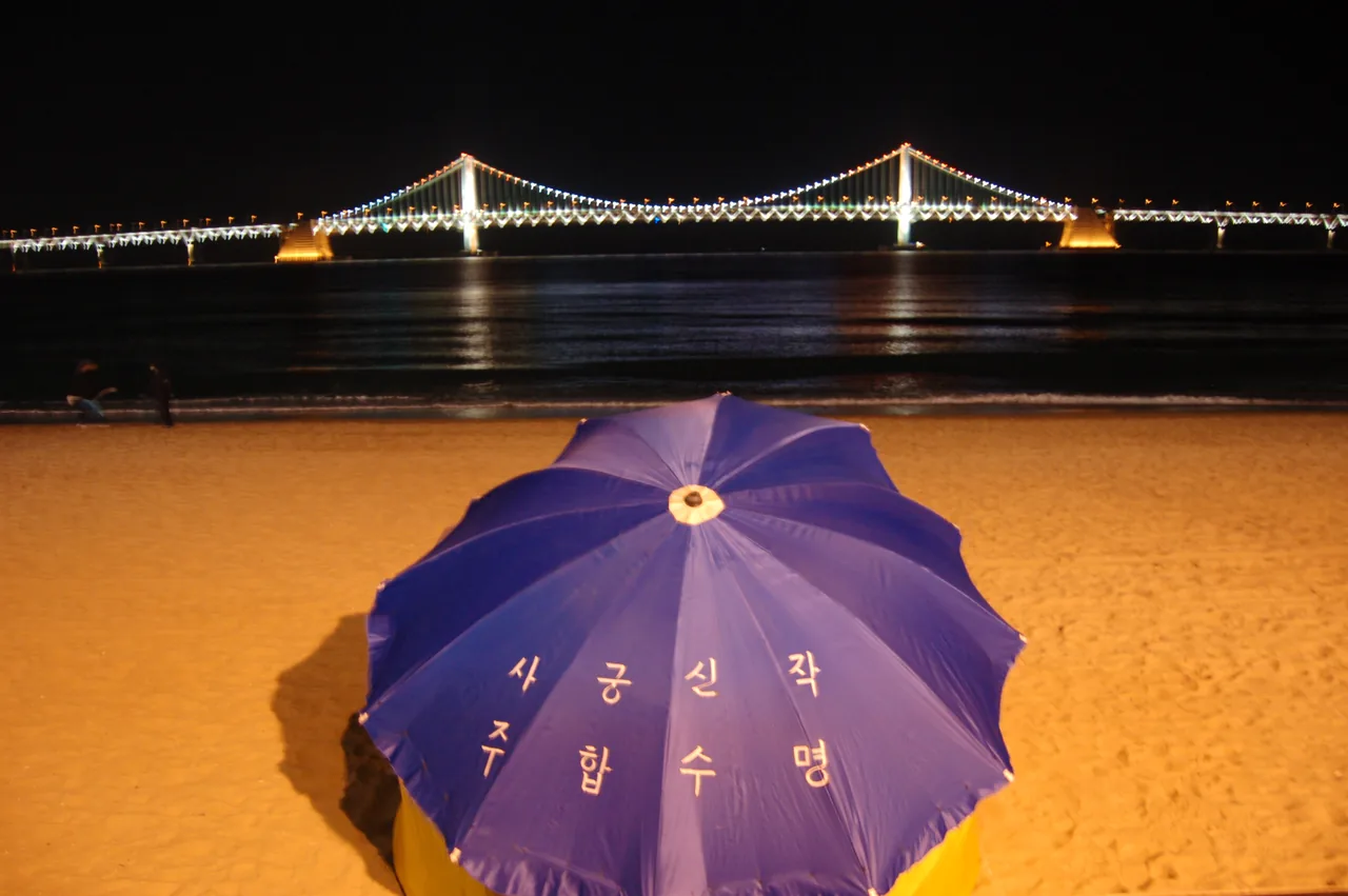 El Puente Gwangan iluminado sobre la Playa Gwangalli de noche en Busan