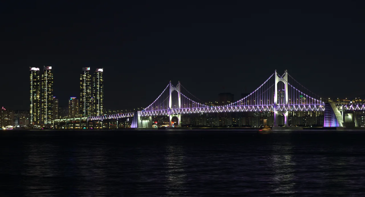 The illuminated Gwangan Bridge with the Marine City skyline at night in Busan