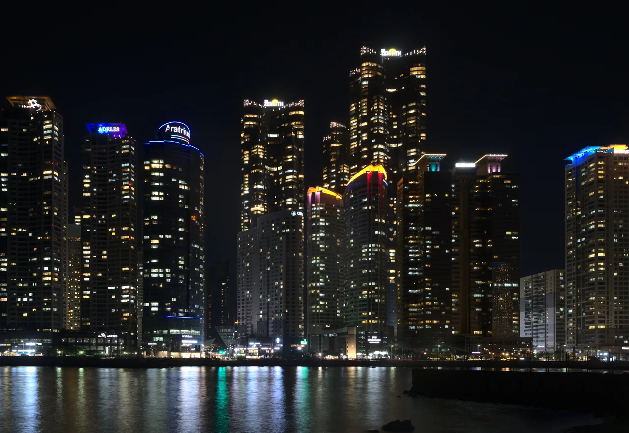Marine City skyscrapers glowing at night reflected on the water in Busan
