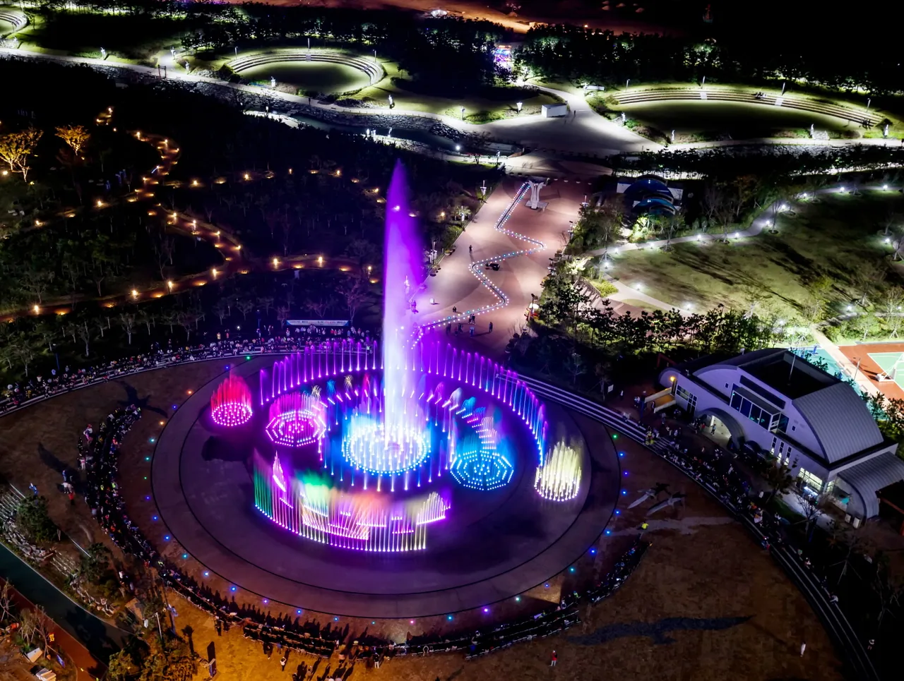 The Sunset Fountain of Dreams at Dadaepo lit at night from above, coloured jets arranged in a wide circle The Sunset Fountain of Dreams at Dadaepo lit at night from above, coloured jets arranged in a wide circle