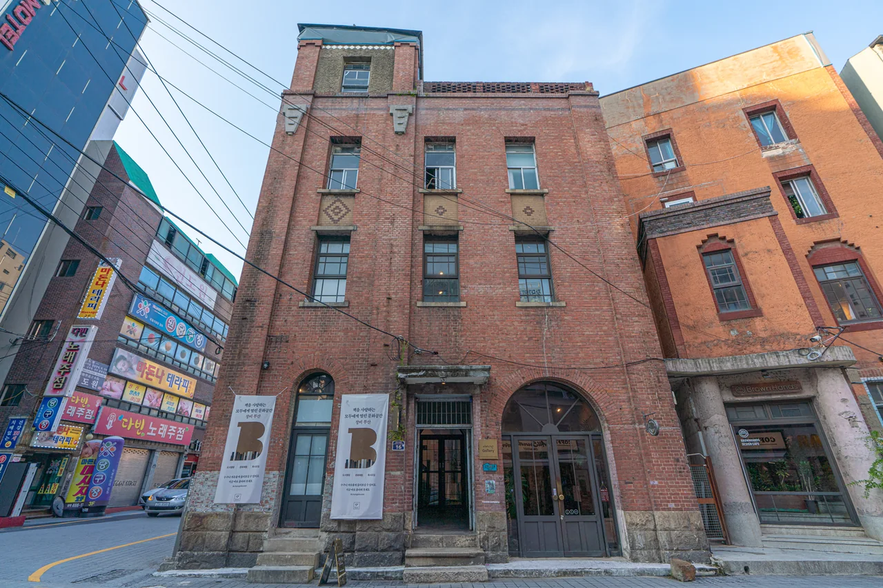 Red brick facade of the four-storey former Baekje Hospital with an arched entrance