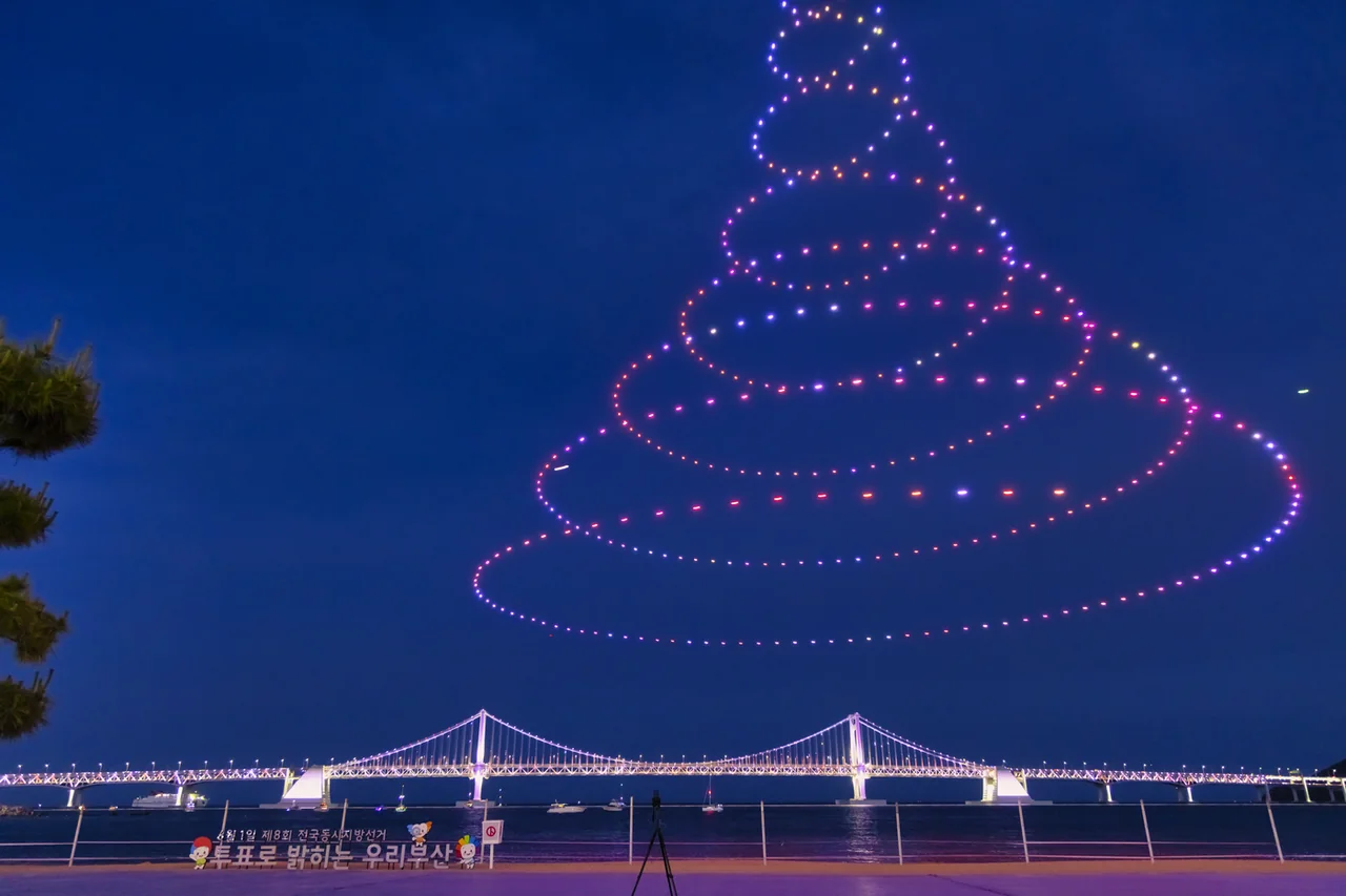 Gwangalli drone light show drawing a spiral above Gwangan Bridge at night