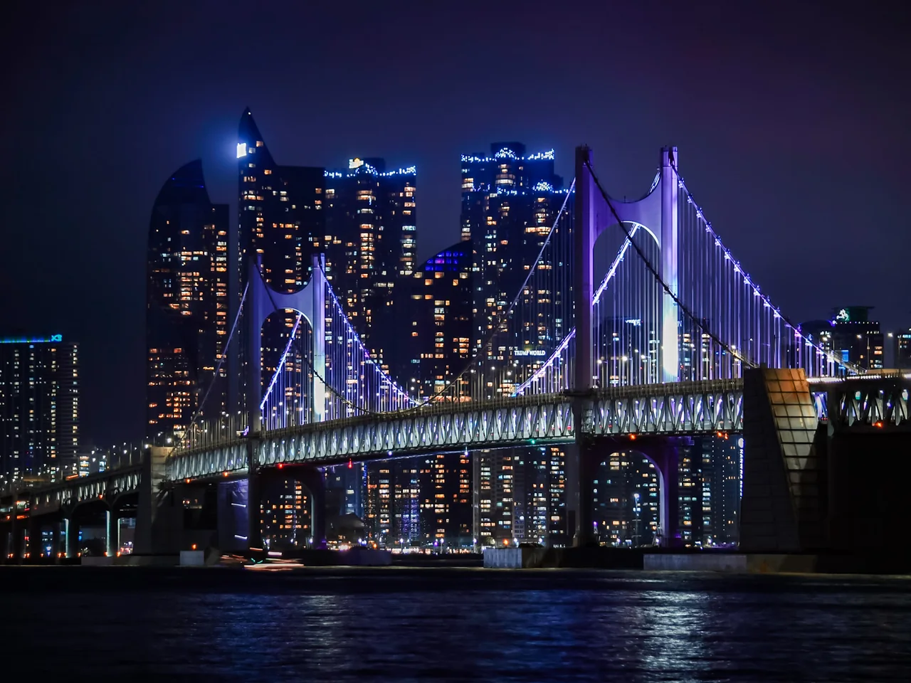 El puente Gwangan iluminado de morado por la noche