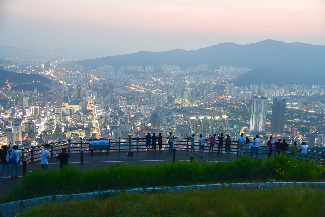 日落剛過時站在荒嶺山觀景台欄杆前的遊客 日落剛過時站在荒嶺山觀景台欄杆前的遊客