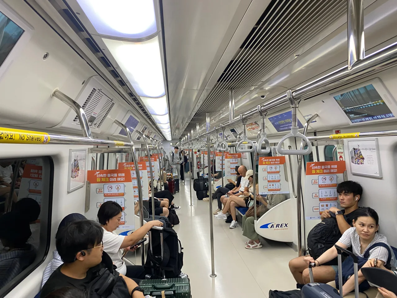 Inside an AREX carriage with passengers and their suitcases