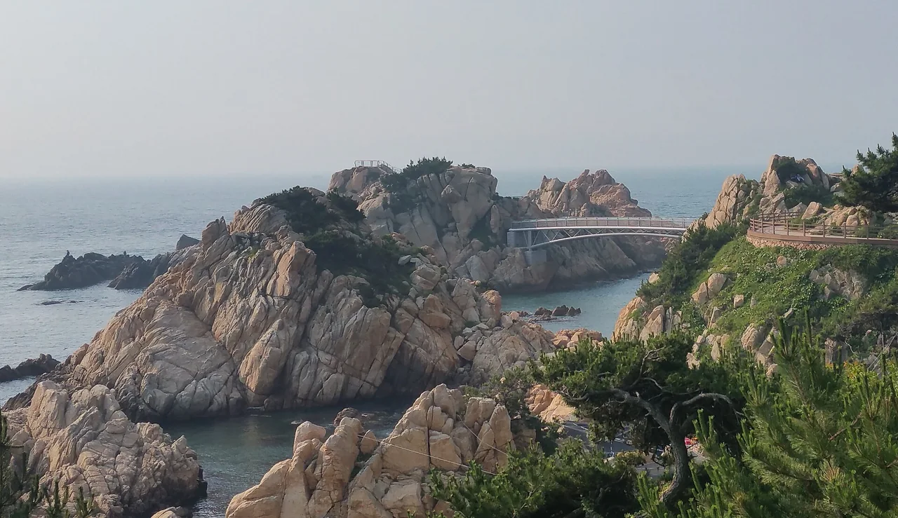 Pale granite rocks at Daewangam Park in Ulsan with a bridge linking the outcrops