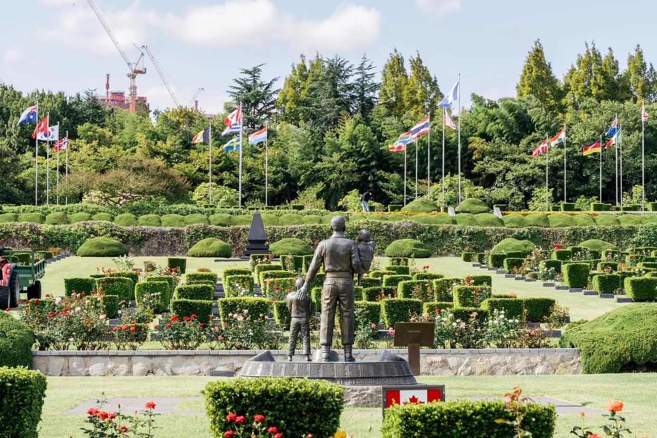Estatua conmemorativa canadiense y banderas de los países participantes