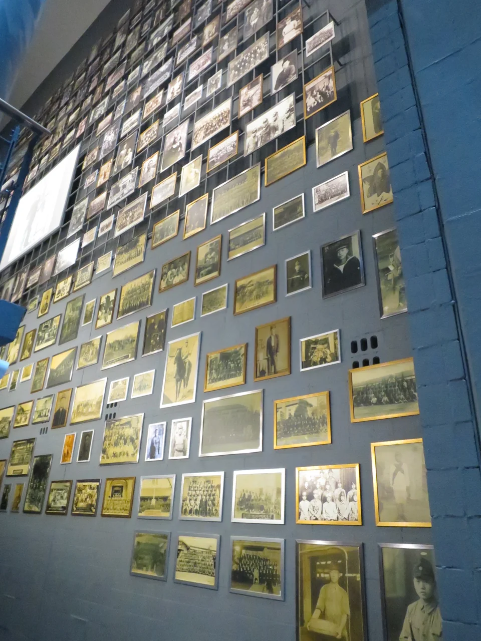 Un muro cubierto de fotografías enmarcadas en el Museo Nacional de la Movilización Forzada