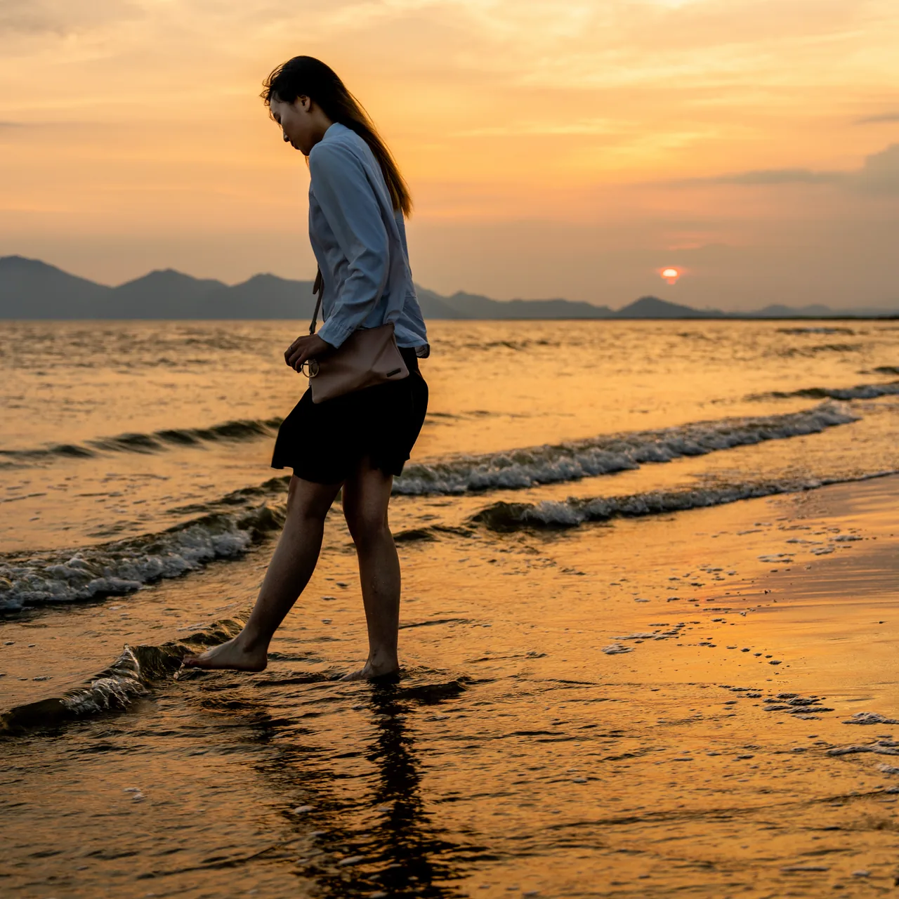 Sunset at Dadaepo with someone walking at the water's edge