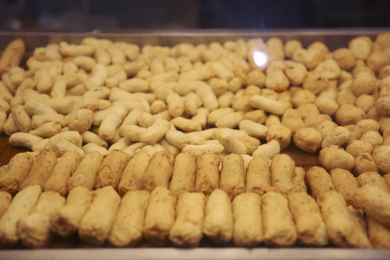 Trays of Busan fish cake stacked in a display case
