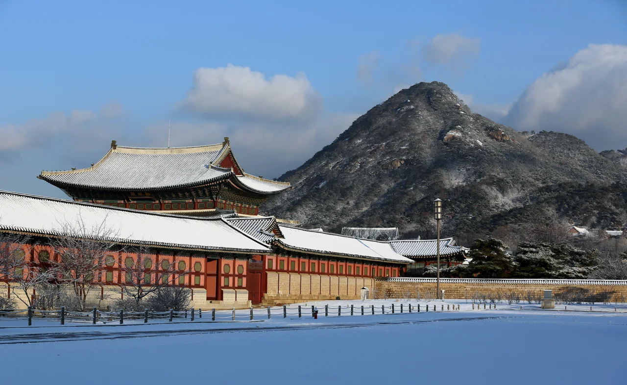 Snow on the roofs of Gyeongbokgung Palace in Seoul with Bugaksan behind