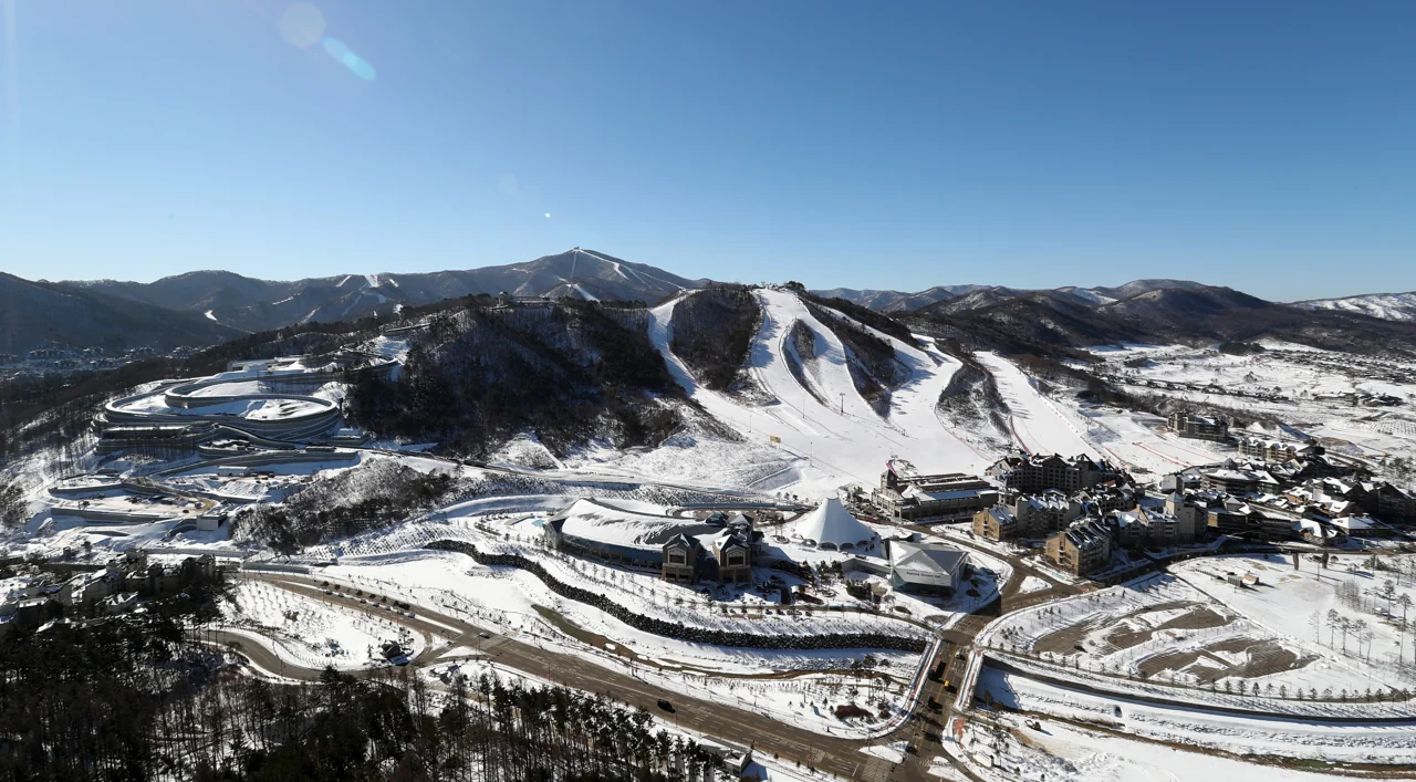 Vista aérea de la estación de esquí de Alpensia, en Pyeongchang, con varias pistas blancas, edificios del complejo y montañas nevadas al fondo