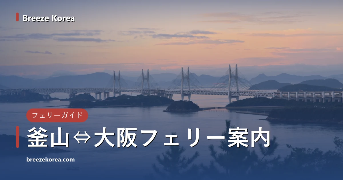 日の出前の淡いピンクの空の下、海を渡る白い斜張橋の連なりと小さな島々。手前に松、海の上に小さな漁船