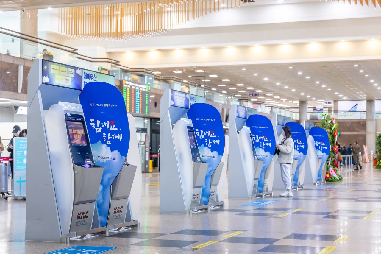 A row of self check-in kiosks in a check-in hall at Gimhae Airport, with travellers using them A row of self check-in kiosks in a check-in hall at Gimhae Airport, with travellers using them